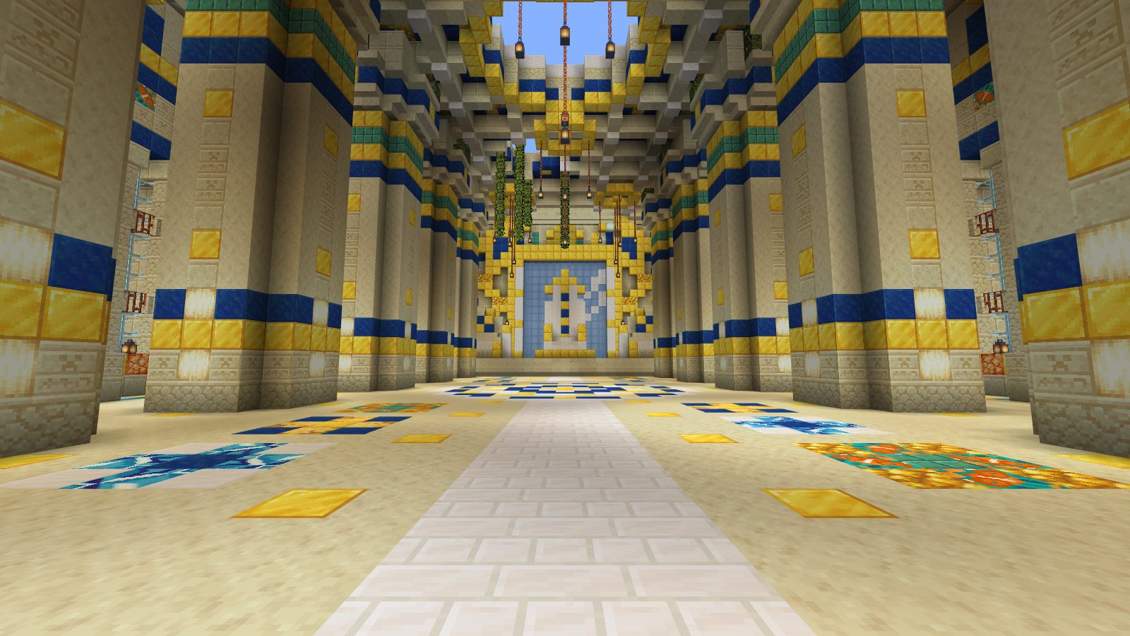 A tall sandstone hall with blue and gold columns leading to a mirror
