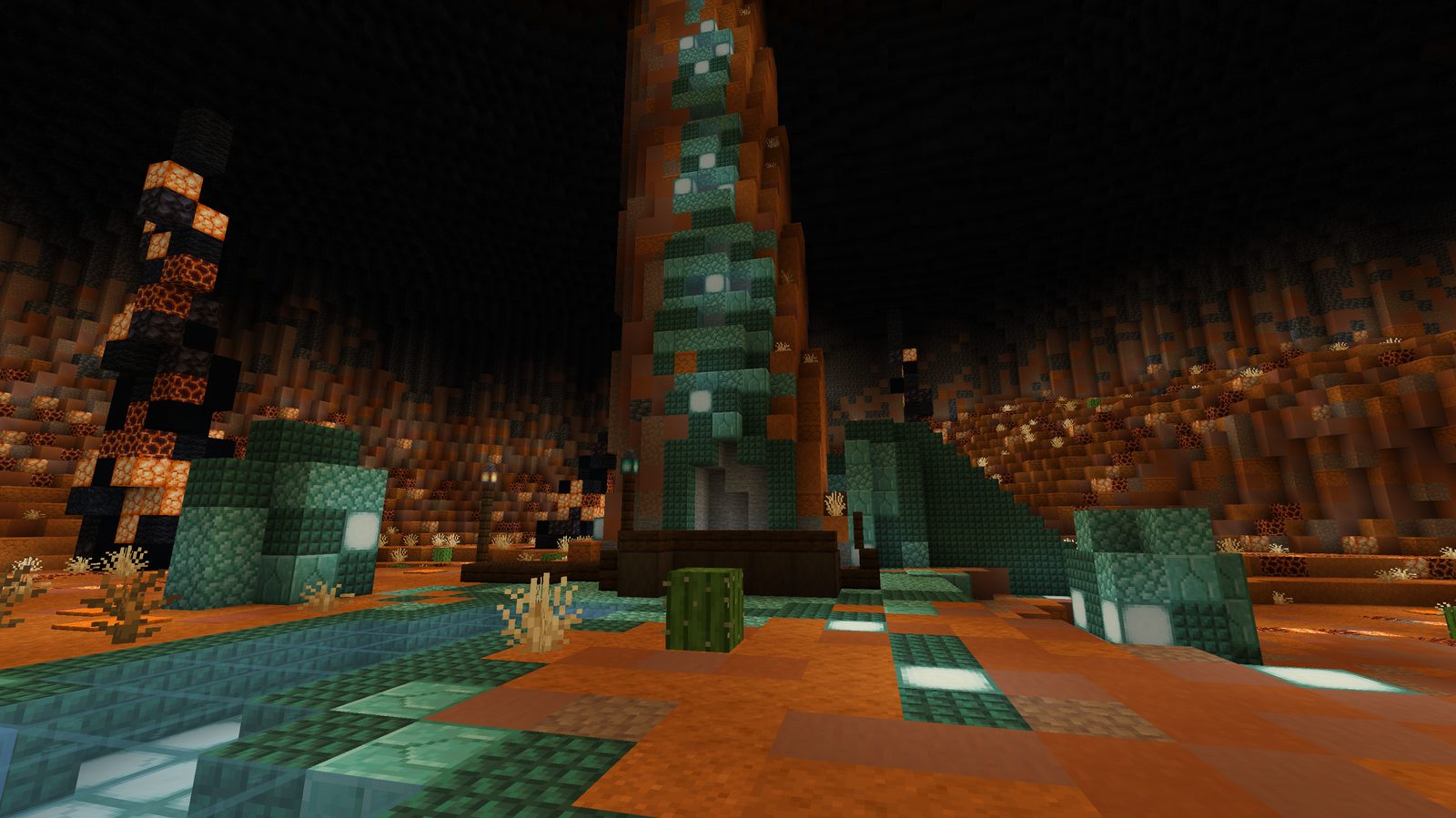 A tall rock spire with a prismarine waterfall over an orange cavern floor