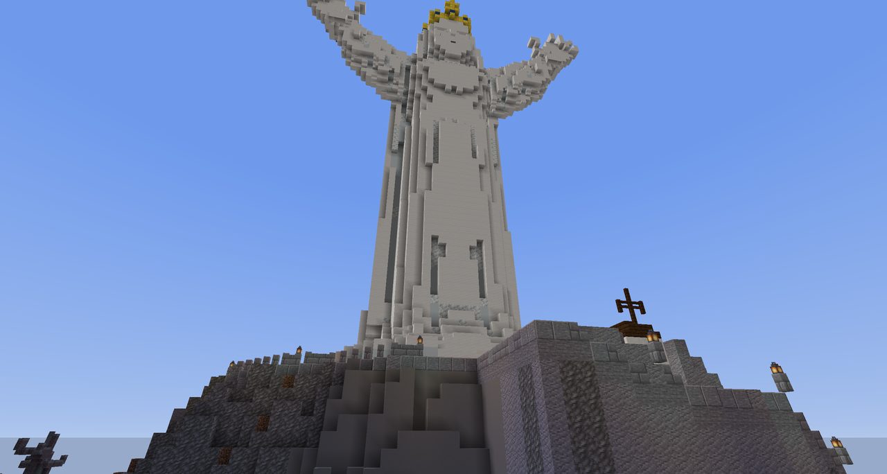 A tall white statue with open arms on a rocky hilltop